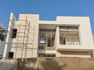 Under Construction luxurious House Or Villa's outdoor view.
Exterior View Of 02 Story Incomplete House With Modern Design.
White Color UnComplete Villa Structure with Erected Scaffolding Pipes around.