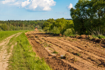 Clearing a dirt country road with a tractor
