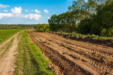 Clearing a dirt country road with a tractor