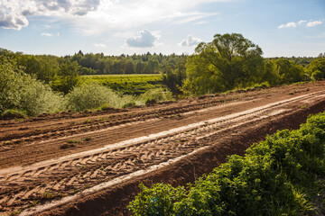 Dirt road along the field leveled by tractor