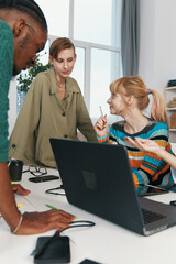 Young adult woman and colleagues socializing and working together in a modern workplace,...