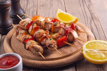 Delicious grilled chicken skewers with capsicum, lemon, salad and ketchup on a plate over the table. Chicken kebab. Healthy food concept.