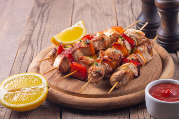 Delicious grilled chicken skewers with capsicum, lemon, salad and ketchup on a plate over the table. Chicken kebab. Healthy food concept.