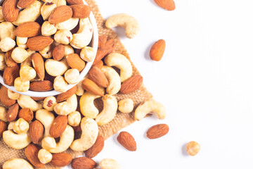 Large assortment of nuts in different bowls on stone table.