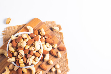 Large assortment of nuts in different bowls on stone table.