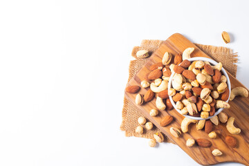 Large assortment of nuts in different bowls on stone table.