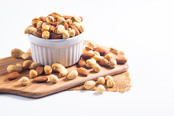 Large assortment of nuts in different bowls on stone table.