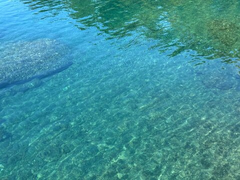 Blue turquoise transparent calm sea water surface natural background.