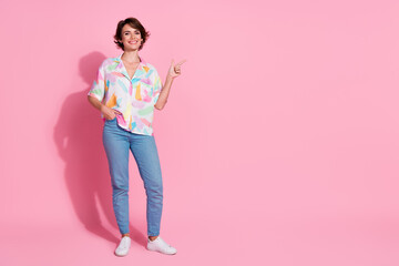 Full length portrait of nice young lady indicate finger empty space wear shirt isolated on pink...
