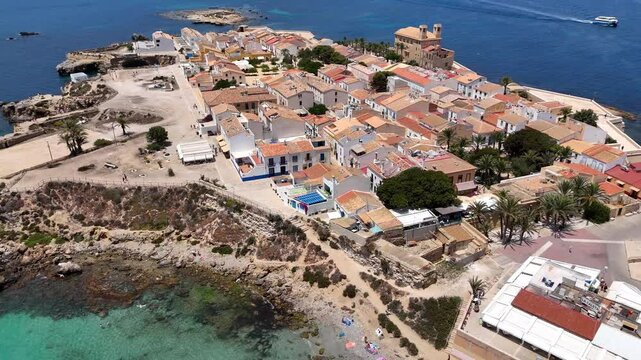 Tabarca Island with San Pedro y San Pablo church and coastal buildings along a vast blue sea