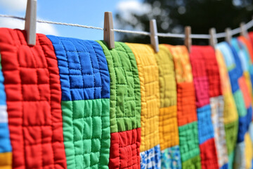 Handmade quilts displayed on a line showcasing vibrant craftsmanship