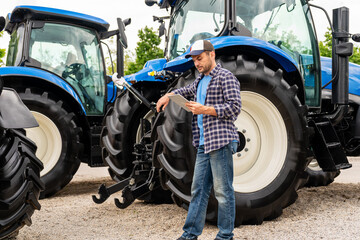 Farm worker with digital tablet near tractor at dealership lot © Barillo_Images