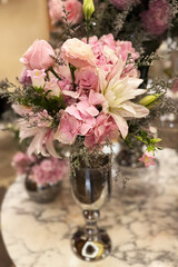 Beautiful floral arrangement in a silver vase with pink flowers at a stylish venue
