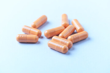 Calcium carbonate capsules. Bright paper background. Soft focus. Close up. Copy space.