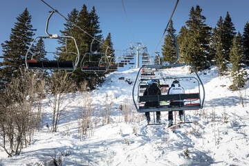 Young skiers on a chairlift heading to a ski competition, Megeve, Haute-Savoie, France