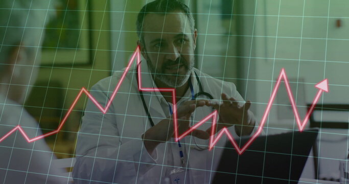 Reviewing doctor in white coat analyzing red data chart on laptop in clinic, with stethoscope