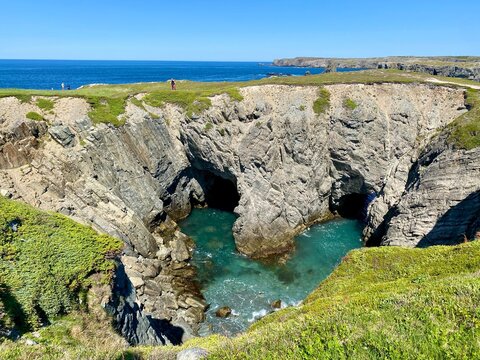 Collapsed sea cave at The Dungeon near Bonavista, Newfoundland, with turquoise Atlantic water, rugged cliffs, and coastal hiking views.