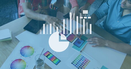 Leaning designers studying color charts and swatches in studio, with digital devices and overlays