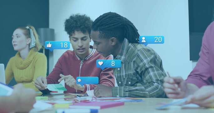 Two men reviewing swatches and jotting in notebooks at meeting table, with laptop and social icons