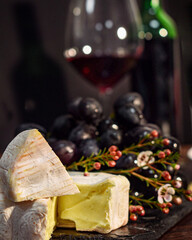Soft cheese, wine, grapes and flowers with glass on table — elegant summer picnic or snack...