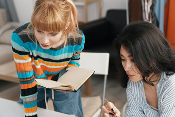 Young adult women colleagues working collaboratively in a modern workplace, socializing and...