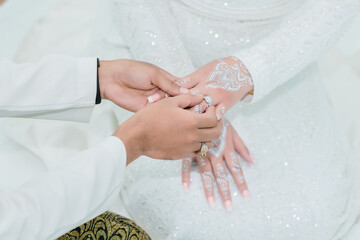 Groom wear wedding rings to left finger of bride, Muslim wedding, malaysia , Indonesia ,Wedding Poster, Close up hand.	