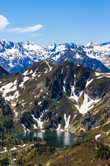 View of Blue Lake from the Col de la Coumeille de l’Ours in spring with snow on the peaks
