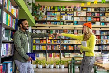 Diverse man and woman exploring books in library setting