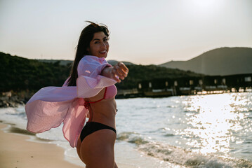 Beautiful woman standing  on the beach enjoying the sunset 