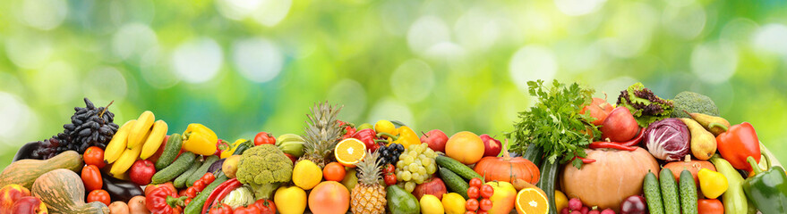 Photo of bright healthy fruits, vegetables and berries on a green natural background.