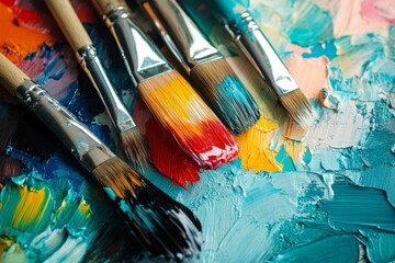 Obraz premium Close up view of paintbrushes resting on a vibrant artist palette filled with various colors