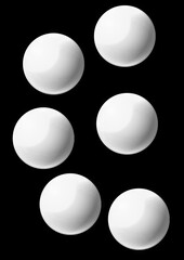 Group of six white balls arranged on black background  
