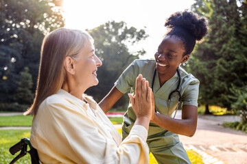 Elderly woman receiving care from nurse in park with greenery