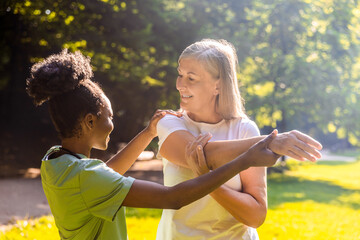 Senior and caregiver engaging in rehab exercise in park