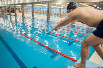Man having a workout in the swimming pool and getting ready to jump