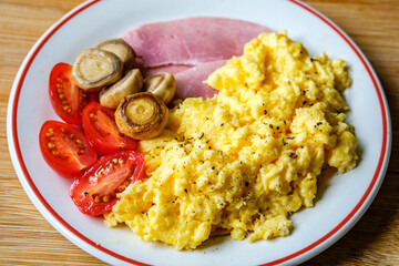 Scrambled Eggs With Fresh Tomatoes Fried Mushrooms and Slices Of Cooked Ham