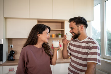 Happy couple drinking milk in modern kitchen