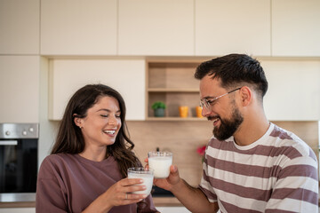 Happy couple drinking milk in modern kitchen