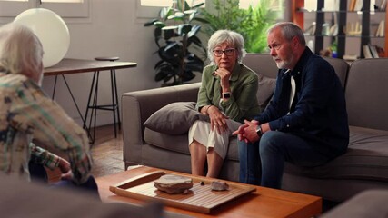 Elderly couple listening to psychologist's advice during therapy session, improving communication and strengthening relationship in comfortable home environment