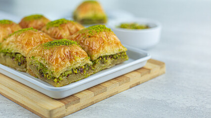 Close-up of pistachio Turkish baklava served on white rectangular plate