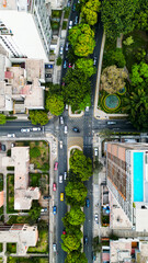 Drone perspective of a street junction with vehicles in motion.