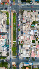Drone view of roads with moving vehicles in an urban setting.