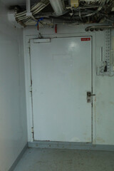 Cruise ship engine room interior with water tight doors electrical and diesel engines, water pipes, measuring instruments, warning signs
