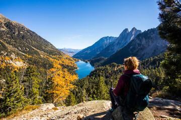 Fototapeta premium Young hiker woman in autumn in Aiguestortes and Sant Maurici National Park, Spain
