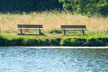 Two empty benches inviting visitors to relax by the lake
