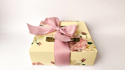 Elegant floral gift box with a pink satin ribbon bow, displayed on a white background. Ideal for...