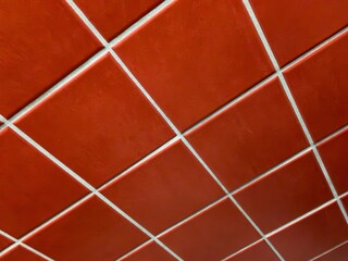 Red tiles on wall, abstract background, perspective view