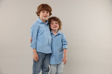 Cute little brothers together on light background. Space for text
