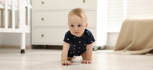 Cute little baby crawling on floor at home