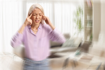 Young woman standing in a living room feeling dizzy